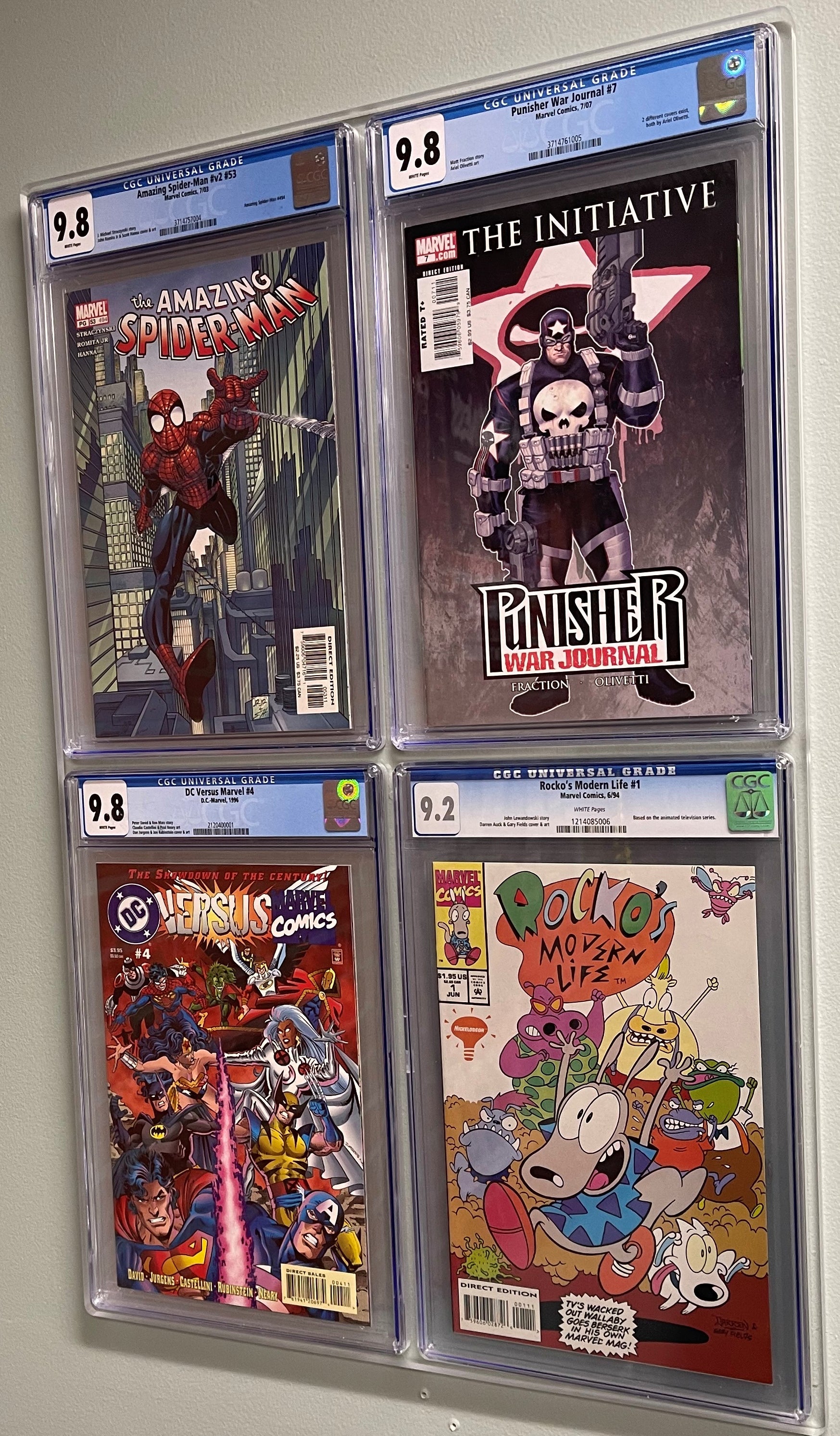 CGC graded comic book display filled with 4 various comics and mounted to the wall, picture is at an angle